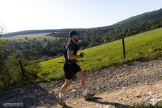 Zdjęcie z ultramaratonu Joga-Kora przedstawia zawodnika biegnącego w górach