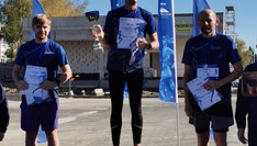 Biegacze na podium zdyplomami i pucharem