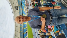Zdjęcie biegacza z medalem na tle stadionu
