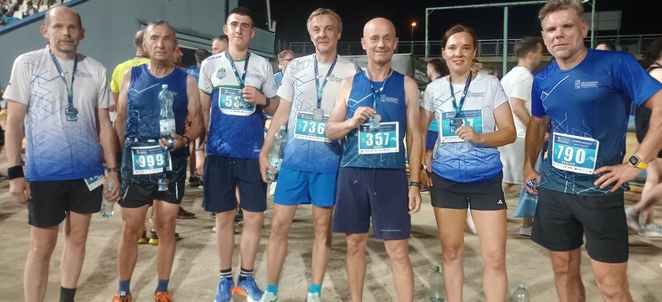 Zdjęcie przedstawia grupę biegaczy z medalami na szyi